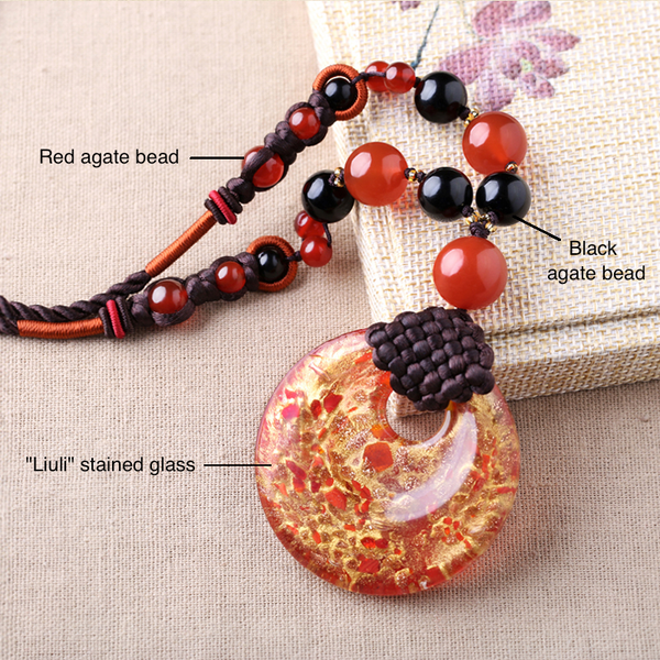 the necklace is made of stained glass, and black and red agate beads