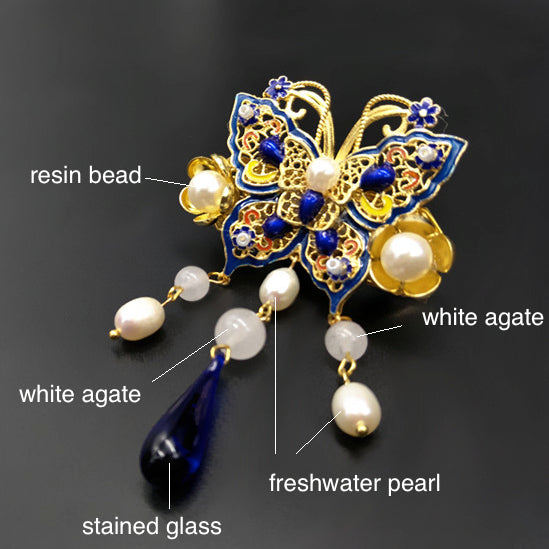 The pin is made with white agate, strained agate, freshwater pearls, and quality metal parts