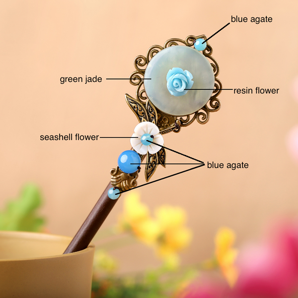 the hair stick is made of wood, decorated with green jade, seashell, and blue agate