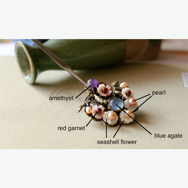details of the hair stick: it is decorated with blue agate, red garnet, pearls, amethyst, and seashell flowers